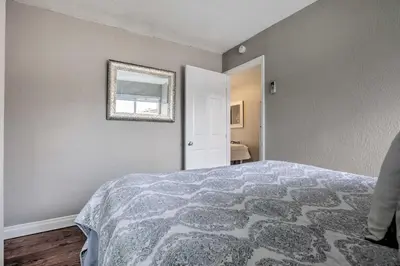a bedroom with a bed and a mirror on the wall at Relaxing Poway Apt with Patio Near Parks and Wineries! in Poway