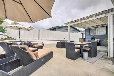 a patio with a table and chairs and an umbrella at Relaxing Poway Apt with Patio Near Parks and Wineries! in Poway