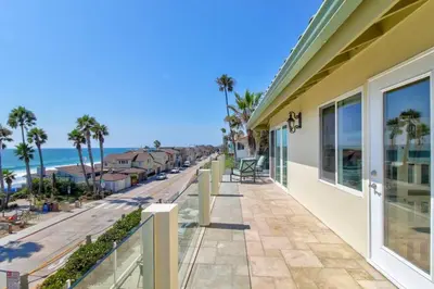 a house with a balcony with a view of the beach at The Bridge At South Oceanside is the Perfect Family Beach House now with AC in Oceanside