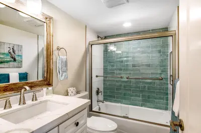 a bathroom with a shower and a sink and a toilet at Carlsbad Village Charm in Carlsbad