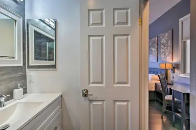 a bathroom with a white door next to a sink at Torrey Spa Suite Modern San Diego Studio! in San Diego