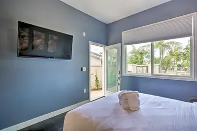 a blue bedroom with a bed and a large window at Torrey Spa Suite Modern San Diego Studio! in San Diego