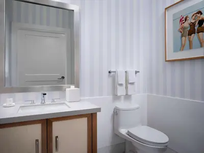 a bathroom with a toilet and a sink and a mirror at Shore House at The Del, LXR Hotels & Resorts in San Diego