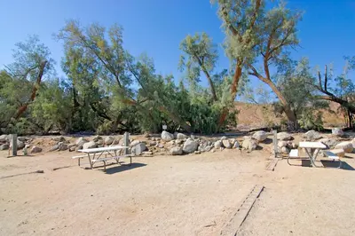 a group of benches sitting on top of a dirt field at Palm Canyon Hotel and RV Resort in Borrego Springs