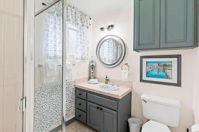 a bathroom with a shower and a toilet and a sink at The Strand Oasis in Oceanside