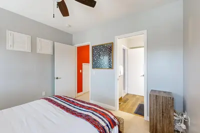 a bedroom with a white bed and an open door at Ingraham Delight Pacific Beach in San Diego