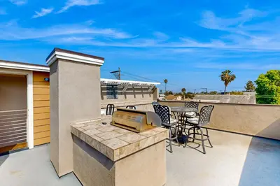 a patio with a grill and a table on a balcony at Ingraham Delight Pacific Beach in San Diego