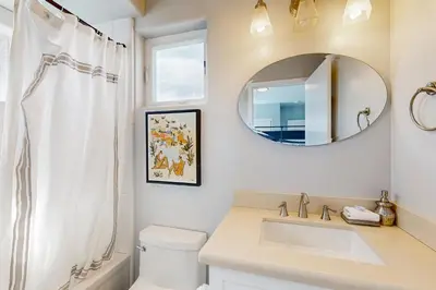 a white bathroom with a sink and a mirror at Ingraham Delight Pacific Beach in San Diego