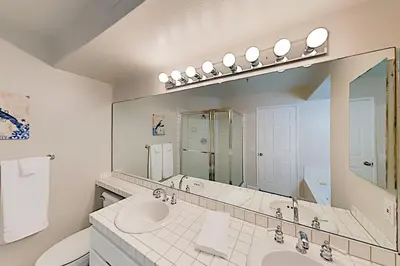 a white bathroom with a sink and a mirror at Imperial Beach Club in Imperial Beach