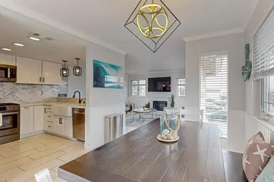 a kitchen with a wooden table and a dining room at Rise and Shine in Newport Beach
