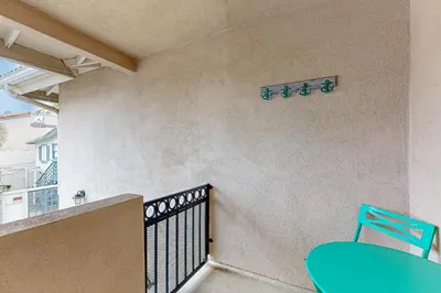 a blue chair on a balcony with a sign on the wall at Rise and Shine in Newport Beach