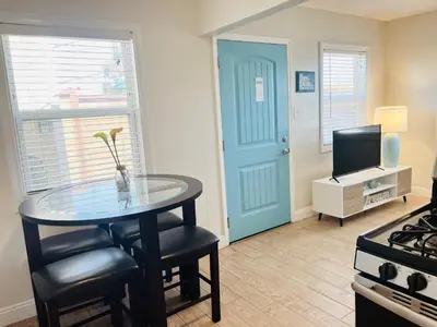 a room with a table and a television and a door at Cozy Beach Cottage with Bicycles in San Diego
