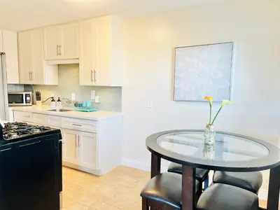 a kitchen with a table with a vase of flowers on it at Cozy Beach Cottage with Bicycles in San Diego