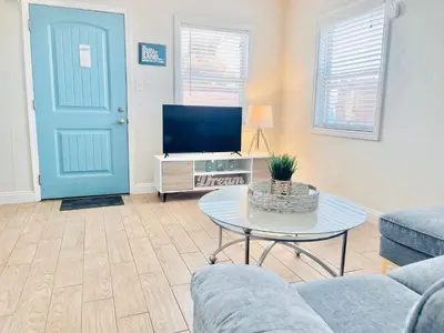 a living room with a blue door and a tv at Cozy Beach Cottage with Bicycles in San Diego