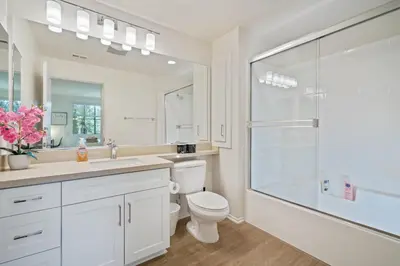 a white bathroom with a toilet and a shower at Luxury Irvine 2Bedrooms 2Bathrooms kitchen Pool apartment in Irvine