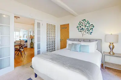 a white bedroom with a bed and a table at Little Italy Charmer in San Diego