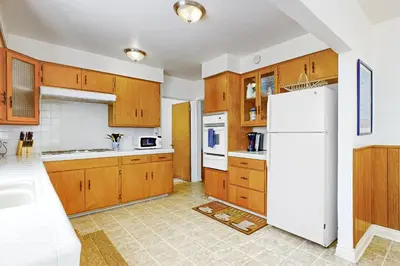 a kitchen with wooden cabinets and a white refrigerator at Little Italy Charmer in San Diego