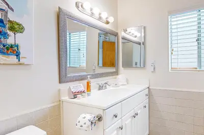 a white bathroom with a sink and a mirror at Little Italy Charmer in San Diego