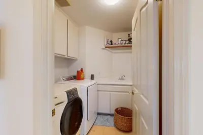 a small kitchen with a washing machine and a sink at Torrey Treats House in San Diego