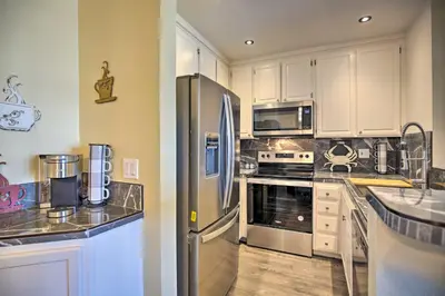 a kitchen with white cabinets and stainless steel appliances at Stunning Oceanside Condo Walk to the Beach! in Oceanside