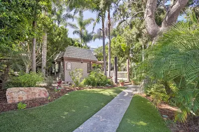 a garden with a small house and a pathway at Stunning Oceanside Condo Walk to the Beach! in Oceanside