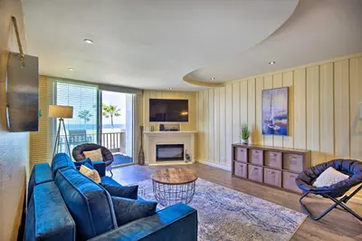a living room with a blue couch and chairs at Stunning Oceanside Condo Walk to the Beach! in Oceanside