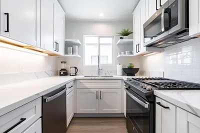 a white kitchen with white cabinets and a stove at The Rosemont II - La Jolla Luxury in San Diego