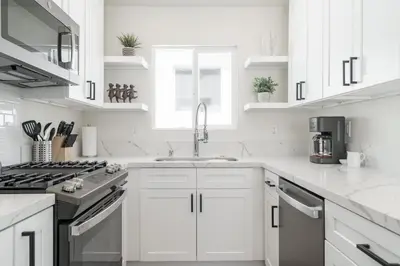 a white kitchen with white cabinets and a sink at The Rosemont IV - La Jolla Luxury in San Diego