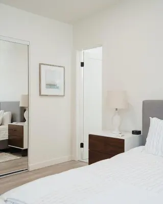 a white bedroom with a white bed and a mirror at The Rosemont IV - La Jolla Luxury in San Diego