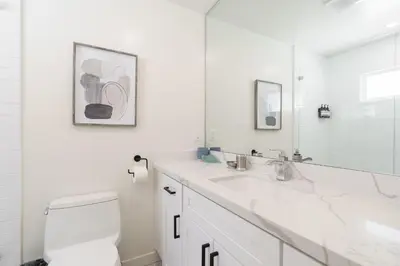 a white bathroom with a toilet and a sink at The Rosemont IV - La Jolla Luxury in San Diego