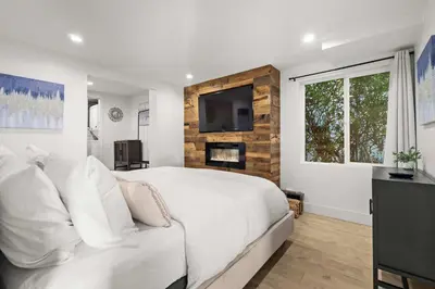 a bedroom with a white bed and a tv on a wall at The California III in San Diego