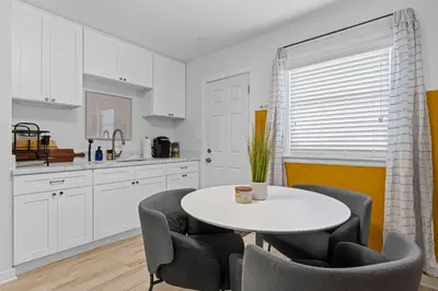 a white kitchen with a white table and chairs at No bad days in San Diego in San Diego