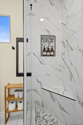 a bathroom with a shower with white marble tiles at Live like a local - Studio with huge backyard in San Diego