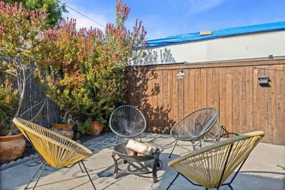 a patio with three chairs and a fence at Live like a local - Studio with huge backyard in San Diego