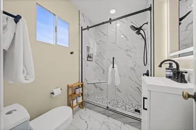 a bathroom with a shower and a toilet and a sink at Live like a local - Studio with huge backyard in San Diego