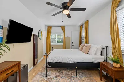 a bedroom with a bed with a ceiling fan at Live like a local - Studio with huge backyard in San Diego