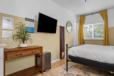 a bedroom with a bed and a tv on the wall at Live like a local - Studio with huge backyard in San Diego