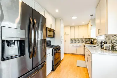 a large kitchen with a stainless steel refrigerator at Canyon Cove Oceanside in Oceanside