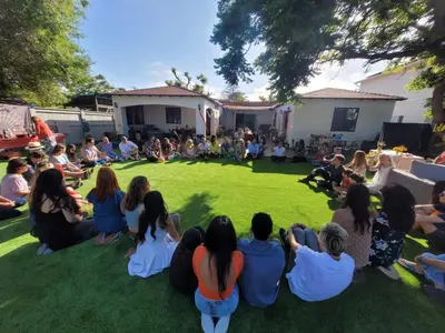 a group of people sitting on the grass watching a concert at Casa Sur in Chula Vista