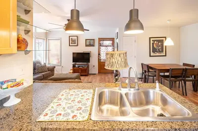a kitchen with a sink and a living room at Serenity House near Gaslamp, San Diego Zoo & Petco in San Diego