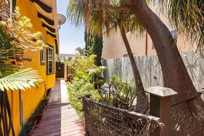 a sidewalk next to a yellow building with palm trees at Serenity House near Gaslamp, San Diego Zoo & Petco in San Diego