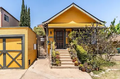 a yellow house with a door and some plants at Serenity House near Gaslamp, San Diego Zoo & Petco in San Diego
