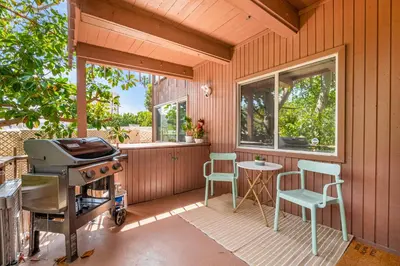 a screened in porch with a grill and a table and chairs at Hideaway Zen in San Diego