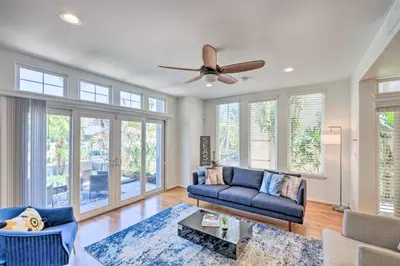 a living room with a couch and a ceiling fan at Oceanside Home with Rooftop Patio - Steps to Beach! in Oceanside