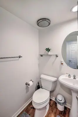 a white bathroom with a toilet and a sink at Oceanside Home with Rooftop Patio - Steps to Beach! in Oceanside