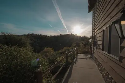 a sun setting over a hill with a house and a sidewalk at Tucker Peak Lodge in Julian