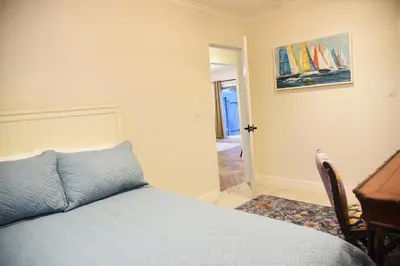 a bedroom with a bed and a desk and a table at Mile to Beach! Fully Fenced Private SoCal Cottage in Oceanside