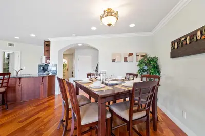 a kitchen and dining room with a wooden table and chairs at Buccaneer Beach Lookout - 30-Night Minimum in Oceanside
