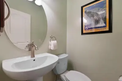 a white bathroom with a sink and a mirror at Buccaneer Beach Lookout - 30-Night Minimum in Oceanside