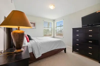 a bedroom with a bed with a lamp and a dresser at Buccaneer Beach Lookout - 30-Night Minimum in Oceanside